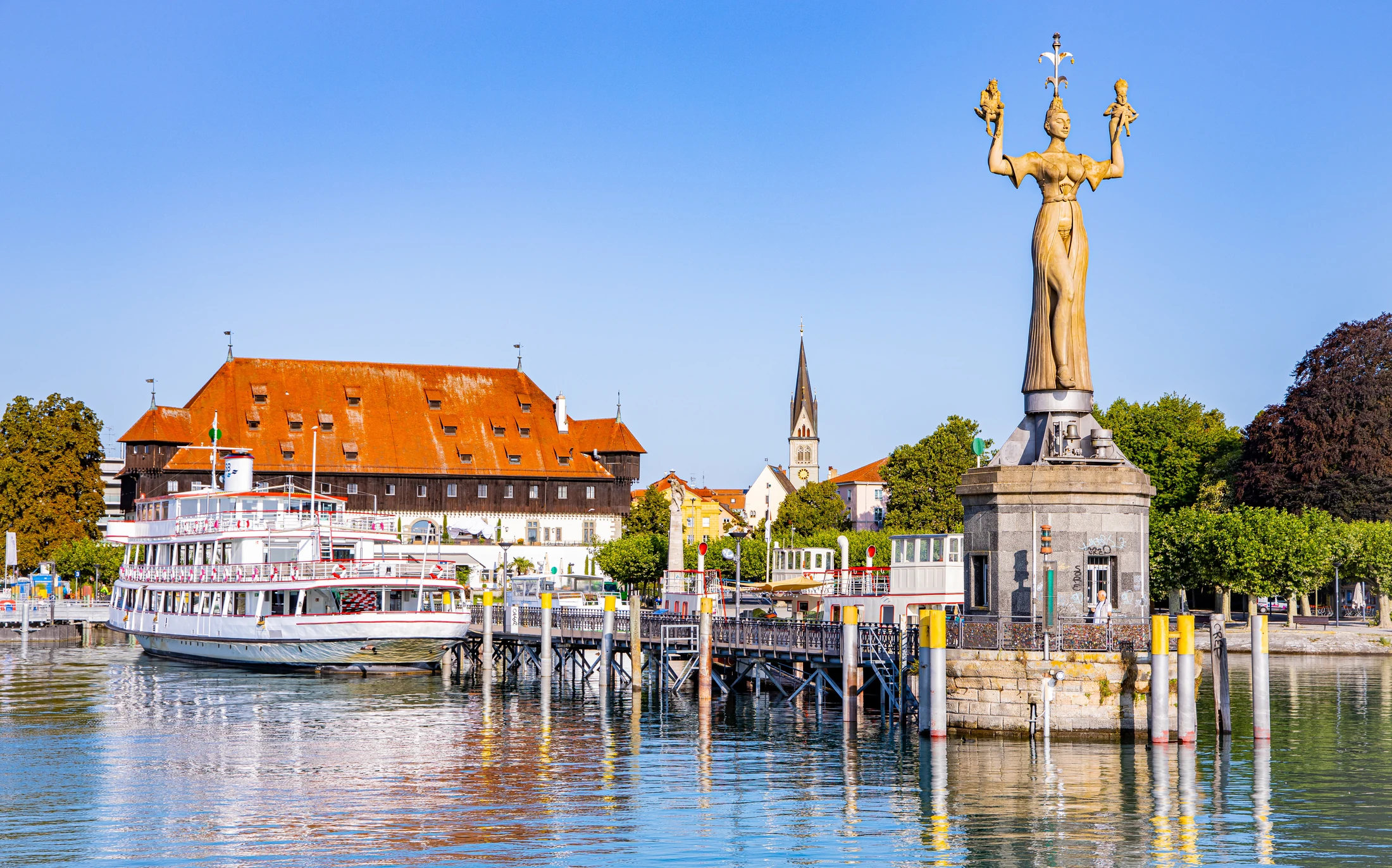 Imperia-Statue und Hafen von Konstanz am Bodensee mit dem Konzilgebäude und einem Ausflugsschiff